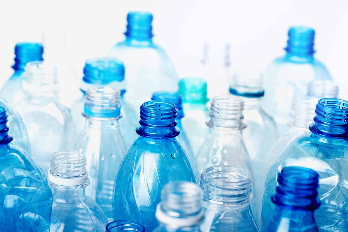 Empty clear and blue PET bottles collected for recycling.